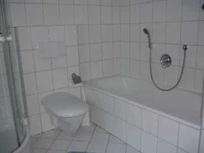 Das Badezimmer ist mit Badewanne und Dusche ausgestattet