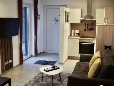 Der Wohnraum mit Eingangstür, Fenster und Küchenzeile