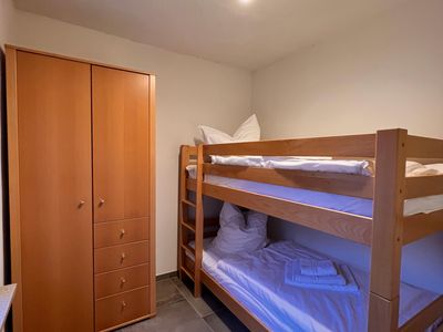 Etagenbett mit Holzschrank in einem der Schlafzimmer