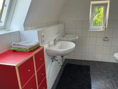Toilette mit zwei getrennten Waschbecken und Kommode im Dachgeschoss