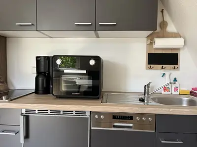 Moderne Küche mit Spülmaschine, Kühlschrank und Tischbackofen