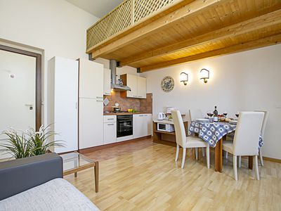 Das Wohnzimmer mit Küchenzeile und der Esstisch aus dem Schlafsofa
