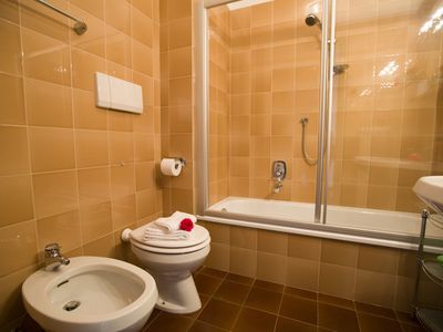 Badezimmer mit Badewanne mit Kopfbrause, Toilet und Bidet