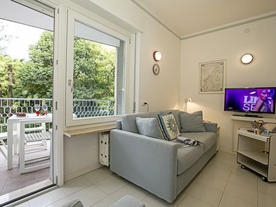 Das Wohnzimmer mit Schlafsofa, TV, Couchtisch und Eingang zum Balkon