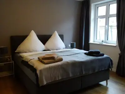 Schlafbereich. Gemütliches Schlafzimmer mit Boxspringbett, alle Fenster mit 3-fach-Verglasung