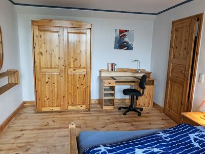Das Schlafzimmer mit Kleiderschrank und Schreibtisch