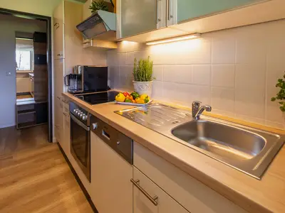 Komplett ausgestattete Einbauküche mit Aussicht auf Gang und Berge