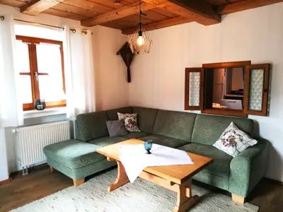 Wohnzimmer mit Couchecke und "Guckerl" in die Küche