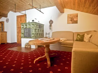 Wohnbereich im Adlernest mit gemütlichem Kachelofen und Schlafsofa