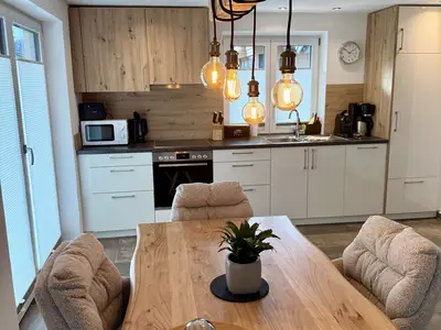 Esstisch mit Küchenzeile und Zugang zum Balkon