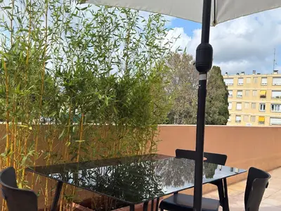 Die Terrasse mit Tisch, Stühlen, Sonnenschirm und 2 Liegestühlen
