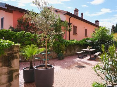 Terrassengarten mit Picknicktisch, Palme und stimmungsvoller Beleuchtung