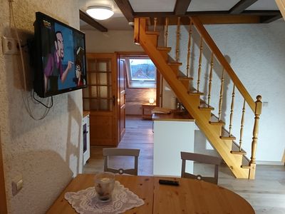 Wohnbereich mit Tür zum Schlafzimmer und Treppe zum Schlafzimmer im DG