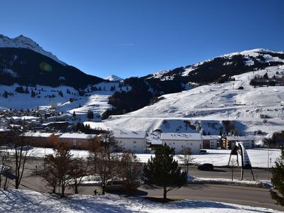 Winter-Aussicht vom Balkon auf Dorf und Skigebiet