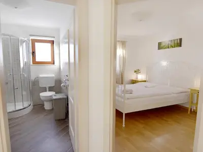 Der Eingang zum Badezimmer und zum Schlafzimmer mit Doppelbett