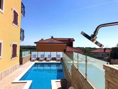 Der Pool mit Außendusche und Liegestühlen