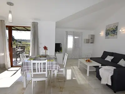Der Wohnbereich mit Schlafcouch, Esstisch, Ausgang zur Terrasse