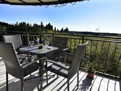 Die überdachte Terrasse mit Tisch und Stühlen, auf der Sie entspannende Momente verbringen können