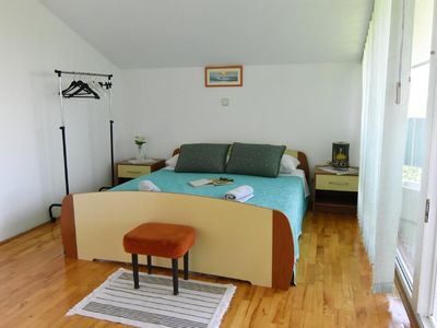 Das Schlafzimmer mit Doppelbett, zwei Nachttischen und Nachtlampen, Kleiderbügeln