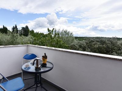 Auf dem Balkon mit Gartenmöbeln können Sie morgens Kaffee genießen und die grüne Landschaft bewundern
