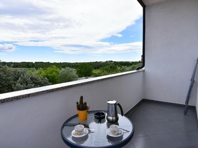 Auf dem Balkon mit Gartenmöbeln können Sie morgens Kaffee genießen und die grüne Landschaft bewundern