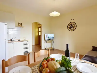Der Wohnbereich mit Küche, Schlafsofa, Flachbild-Sat-TV und Esstisch