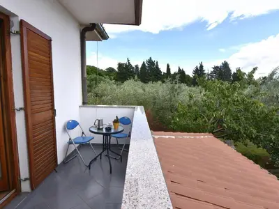 Auf dem Balkon mit Gartenmöbeln können Sie morgens Kaffee genießen und die grüne Landschaft bewundern