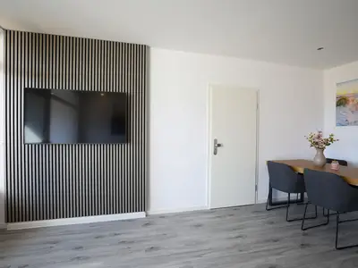 Strandkoje 105 Scharbeutz: Moderner Essbereich mit großem Tisch und Smart-TV im stilvollen Ambiente.