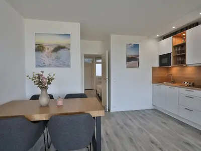 Strandkoje 105 Scharbeutz: Essbereich mit stilvollem Holztisch und moderner Einbauküche.