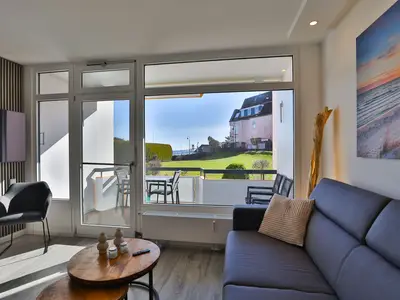 Strandkoje 104: Modernes Wohnzimmer mit Balkon und Teilmeerblick in Scharbeutz.