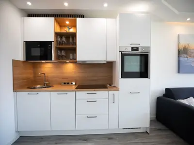 Strandkoje 105 Scharbeutz: Moderne Einbauküche mit hochwertigen Geräten und stilvollem Design.