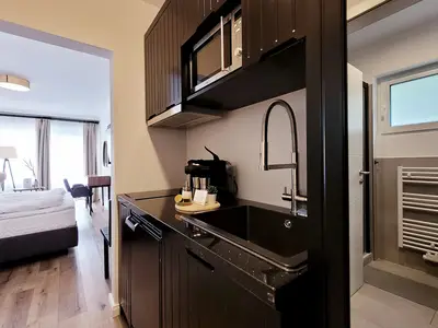 Küche mit Herd, Mikrowelle, Kühlschrank, Wasserkocher und Caffissimo-Kaffeemaschine