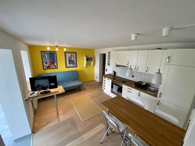 Wohnküche mit klappbarer Couch und Flatscreen-TV