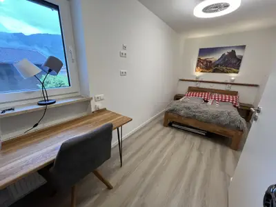 Schlafzimmer mit Schreibtisch und geräumigem Kleiderschrank