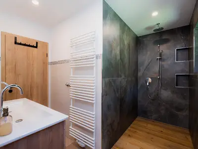 Badezimmer mit großer Regendusche und zwei Fenstern