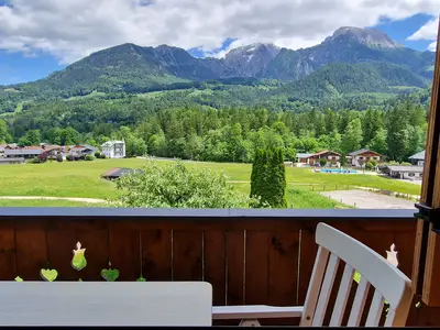 Blick durchs Wohnzimmerfenster auf Balkon und Umgebung