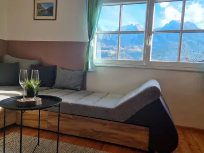 großes L-Sofa direkt neben dem Kamin und Traum Bergblick