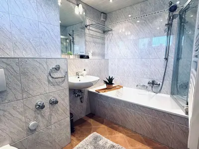 Badezimmer mit Badewanne und Dusche mit WC