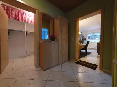 Diele mit Garderobe -  Blick in begehbaren Schrank und Küche