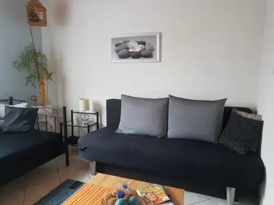 Wohnzimmer mit ausziehbarem Sofa und zusätzlichem Einzelbett