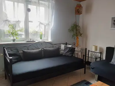 Wohnzimmer mit Einzelbett und ausziehbarem Sofa
