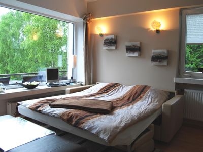 Wohnbereich. Zusätzliches integriertes Doppelbett im Wohnzimmer und Fernblick auf die Alpen