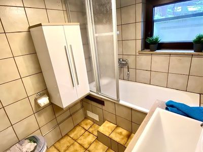 Unser Badezimmer mit Badewanne. In den Schränken finden Sie Hand- und Badetücher