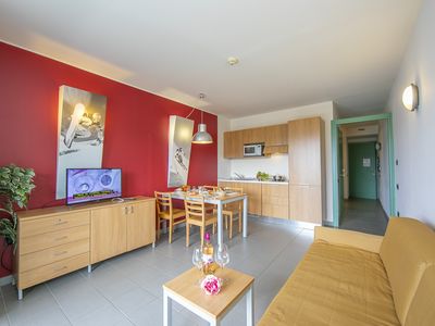 Wohnbereich mit Schlafsofa und Blick auf Küche und Korridor