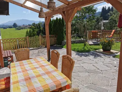 Sonnige Terrasse mit Teilüberdachung