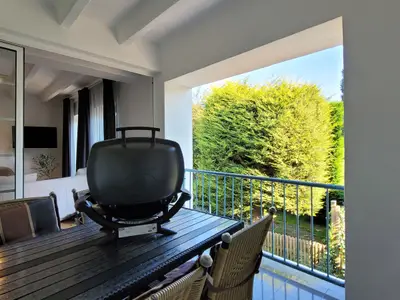 Überdachte Terrasse mit Gartentisch und Stühlen