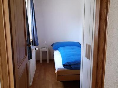Kleines Einzelzimmer mit Bett und Schrank