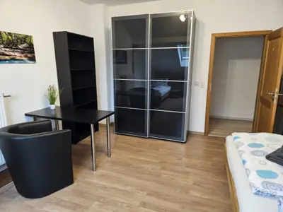 Kleines Schlafzimmer mit Schrank und Schreibtisch