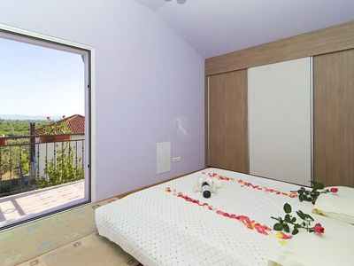 Ein Schlafzimmer mit einem privaten Balkon und Blick auf den Pool.