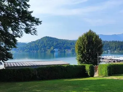 Balkonblick auf Liegewiese und See und Berge